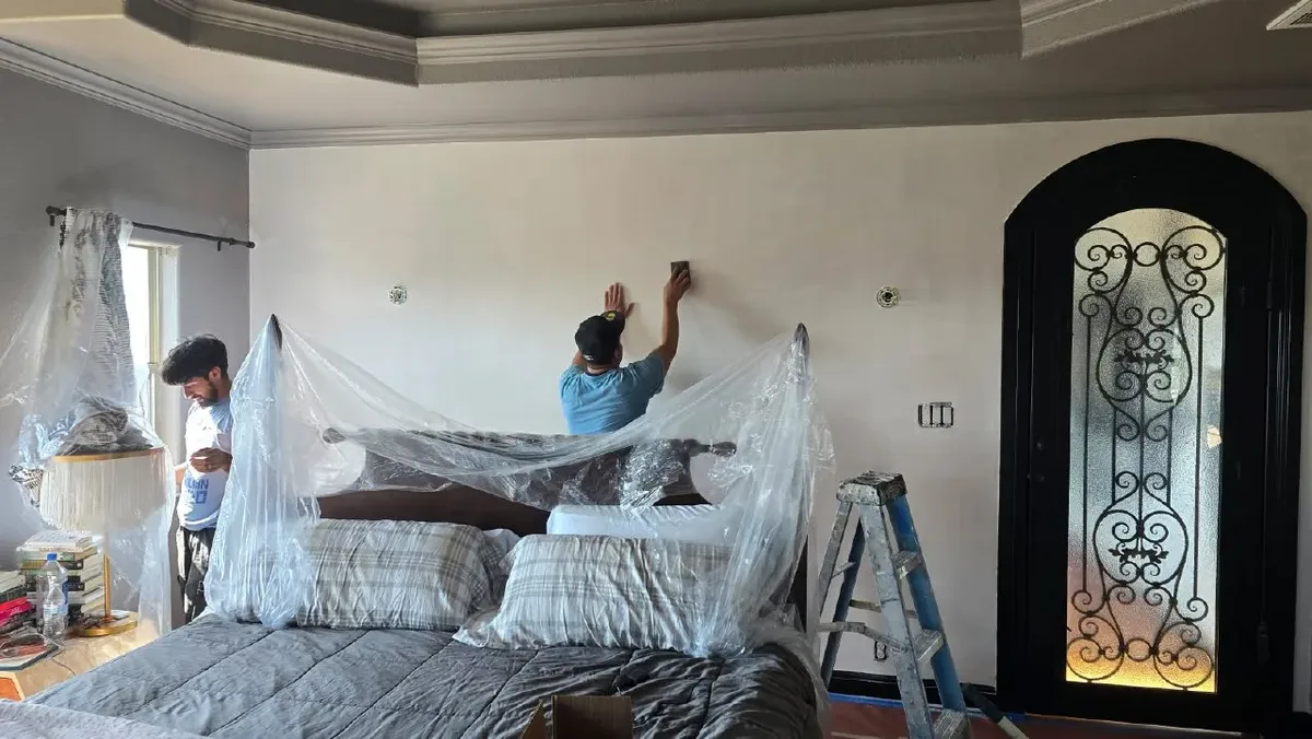 Professional wallpaper removal process showing careful stripping technique