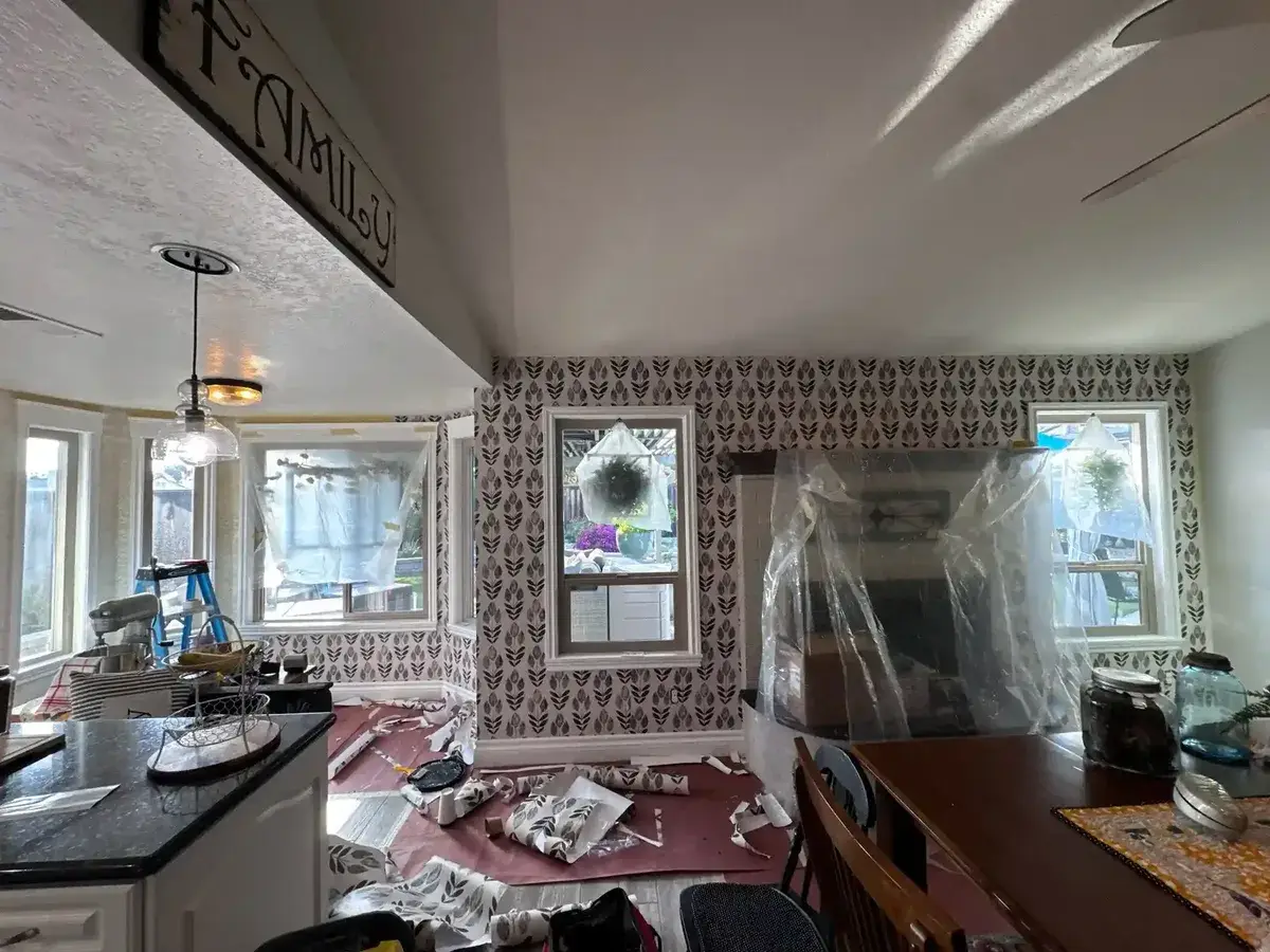 Professional wallpaper removal showing careful stripping process